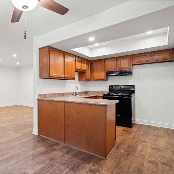 a kitchen with wooden cabinets and a black dishwasher.