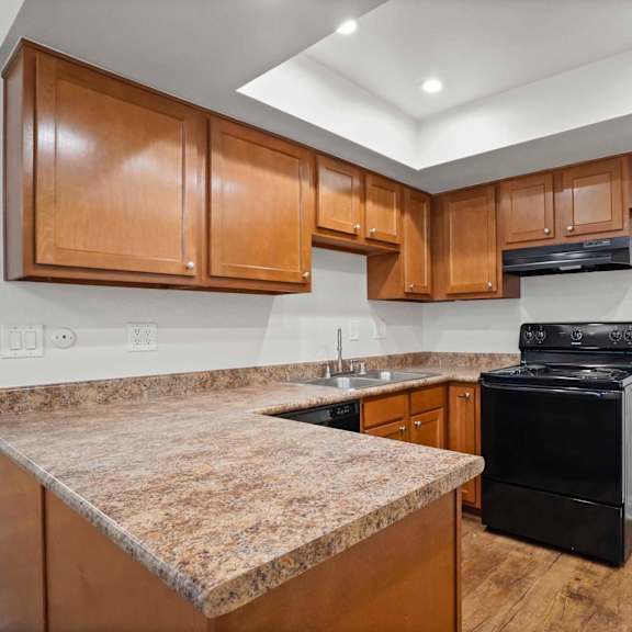 a kitchen with a granite counter top and wooden cabinets.