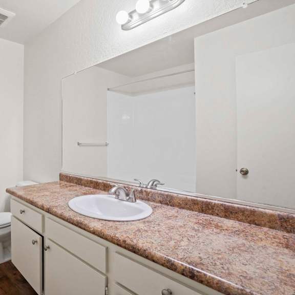 a bathroom with a granite countertop and white fixtures.