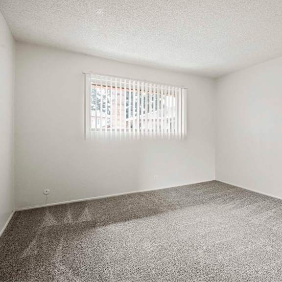 a room with a window and carpeted floor.