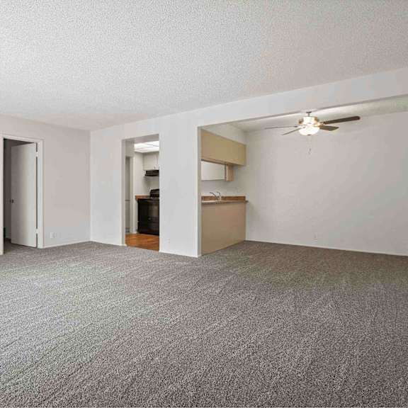 a room with a carpeted floor and a ceiling fan.