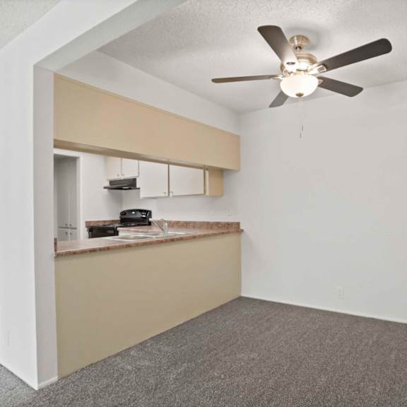a room with a ceiling fan and a window with blinds.