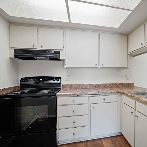 a kitchen with white cabinets and a black stove top oven.