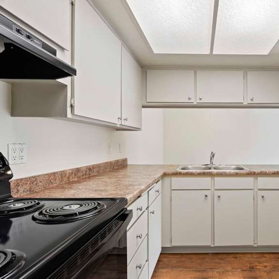 a kitchen with white cabinets and a black stove top.