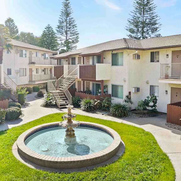 a courtyard with a fountain in the middle of it.
