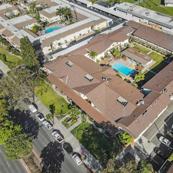 an aerial view of a residential area with houses and a swimming pool.