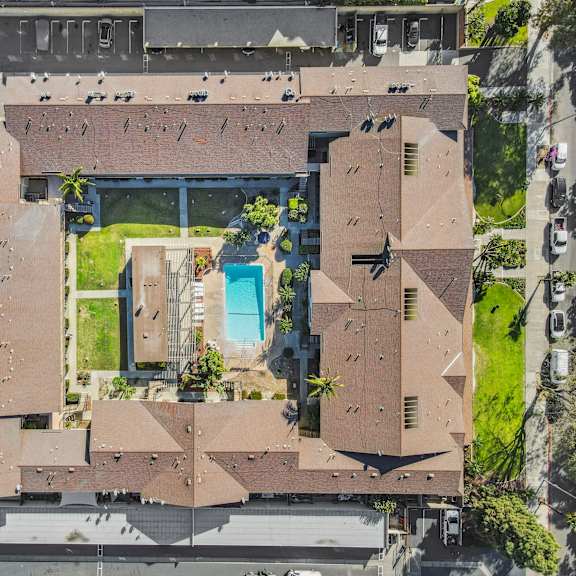 a large brown building with a pool in the middle.