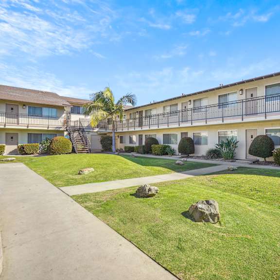 a sunny day at a well-kept apartment complex with a clear blue sky.