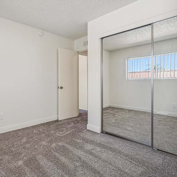 a room with a carpeted floor and a mirror on the wall.
