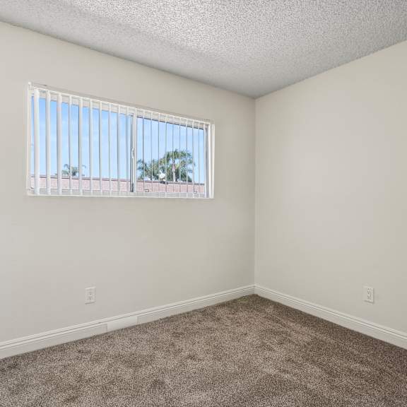a room with a carpeted floor and a window.