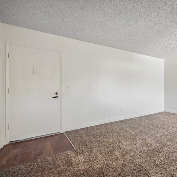 a room with a white door and carpeted floor.