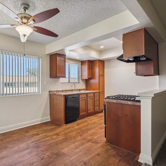 a kitchen with wooden floors and a ceiling fan.