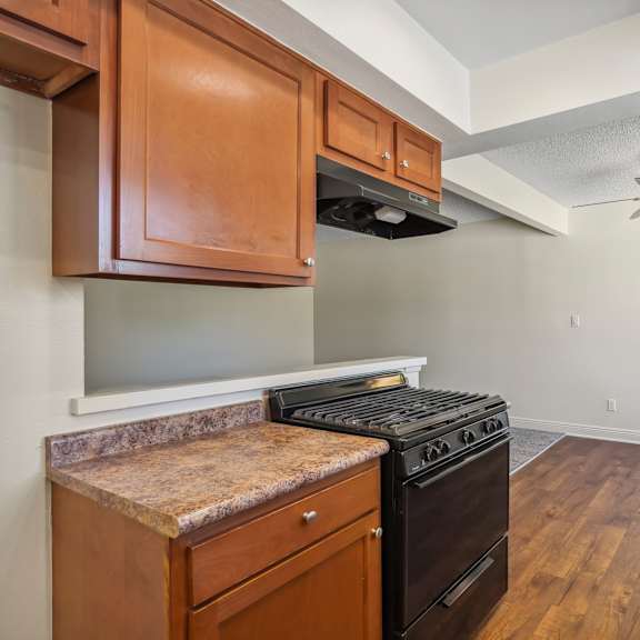 a kitchen with wooden cabinets and a black stove top oven.