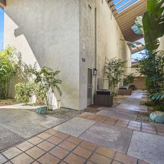 a courtyard with a tiled floor and a building with a door.