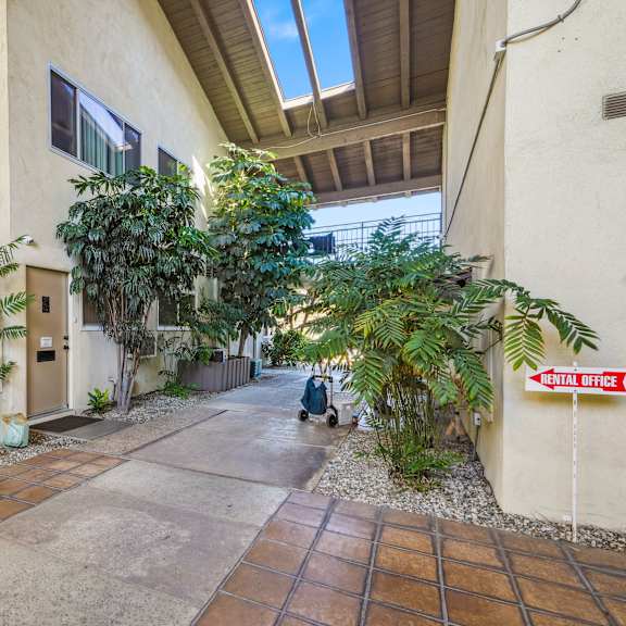 a courtyard with a red sign that says "rental office".