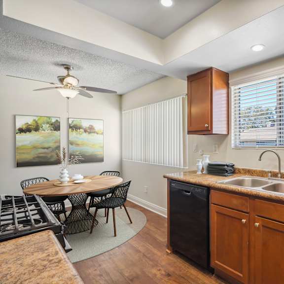 a kitchen with wooden cabinets and a black trash can.