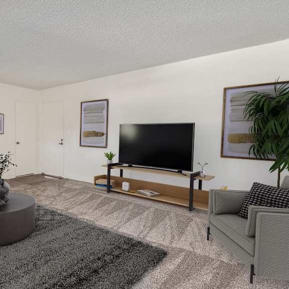 a living room with a grey sofa, a grey rug, a grey coffee table, a flat screen tv, and a potted plant.