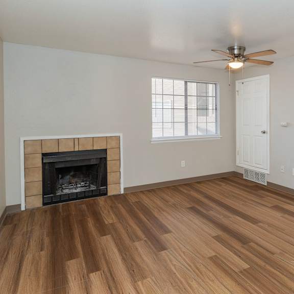 a room with a fireplace and wood flooring.