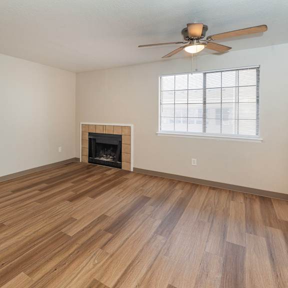 a room with a fireplace and a ceiling fan.