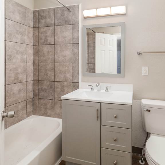 a bathroom with a toilet, sink, and bathtub.