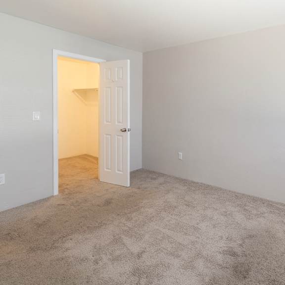 a room with a carpeted floor and a doorway leading to another room.