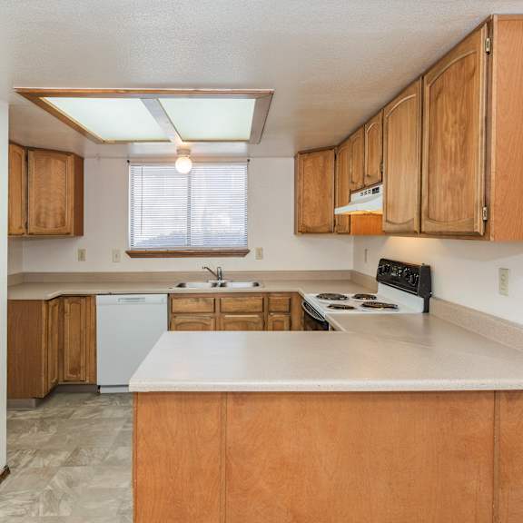 a kitchen with wooden cabinets and a white countertop.