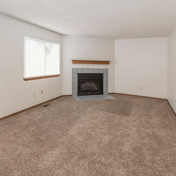 a room with a fireplace and carpeted floor.