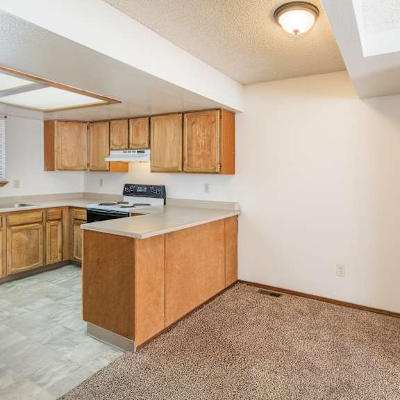 a kitchen with wooden cabinets and a white countertop.