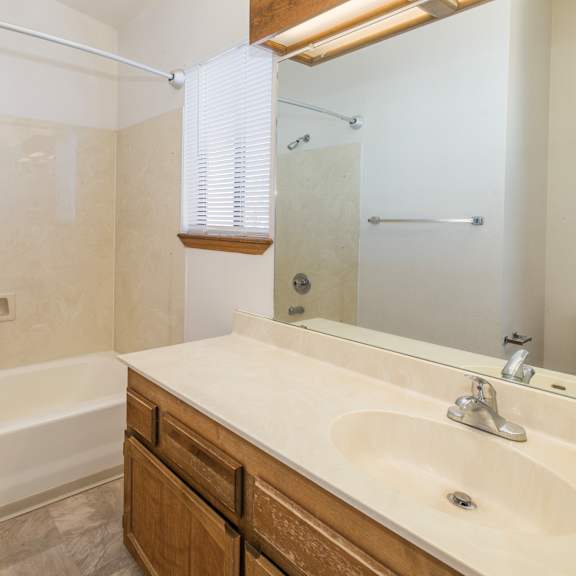 a bathroom with a white tub and sink.