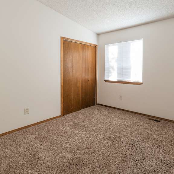 a room with a brown door and carpeted floor.