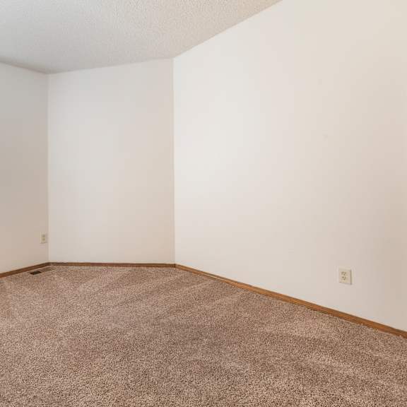 a room with a window and carpeted floor.