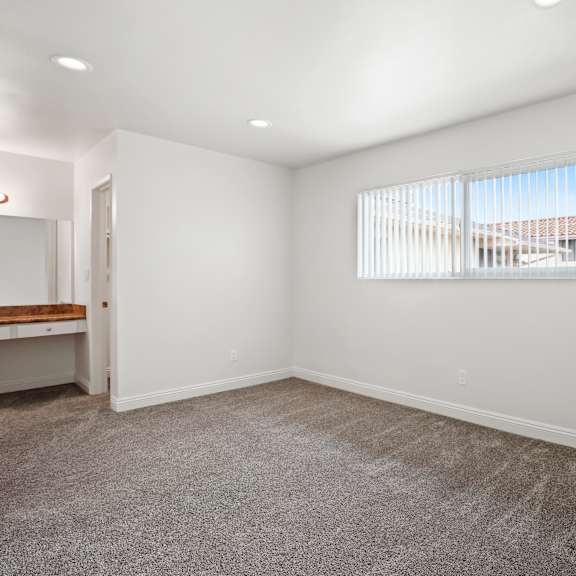 a room with a window and a carpeted floor.
