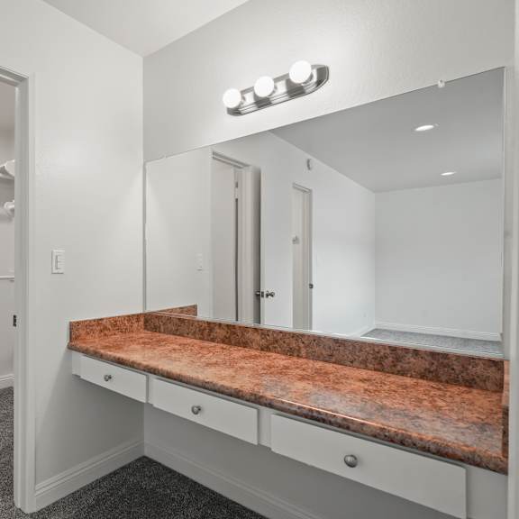 a bathroom with a marble countertop and a large mirror.
