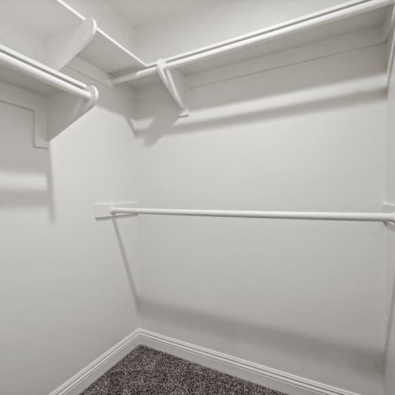 a white closet with a door and a mat on the floor.