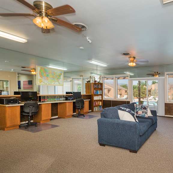a spacious living room with a blue couch and a ceiling fan.