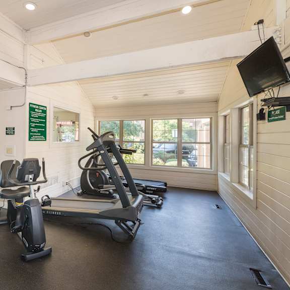 a gym with treadmills and exercise bikes.