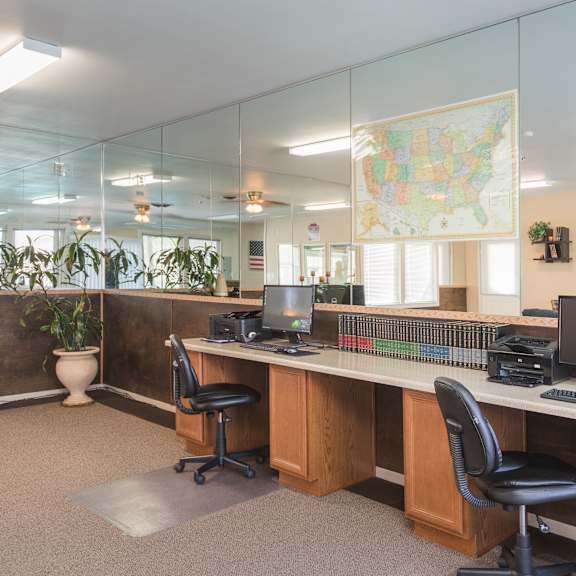 a room with a map of the united states on the wall and two desks with computers and monitors.