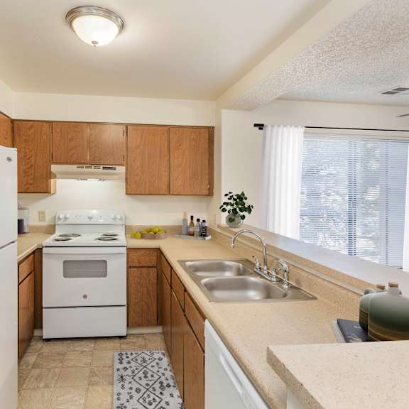 a kitchen with a white refrigerator, stove, and sink.