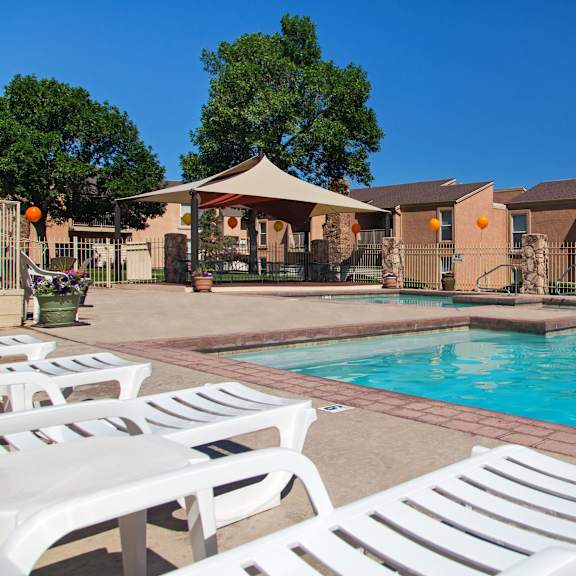 a pool surrounded by white lounge chairs.