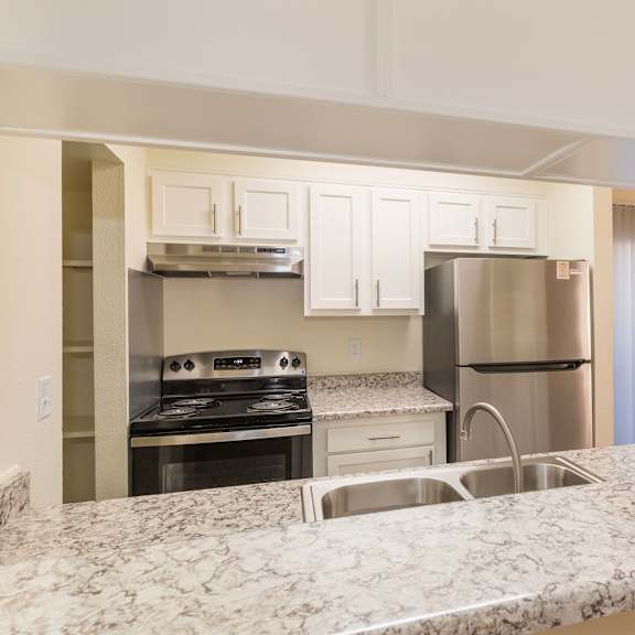 a kitchen with a granite countertop and stainless steel appliances.