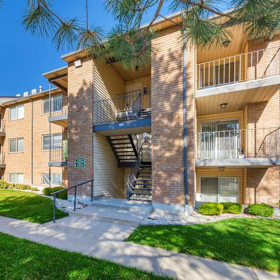 apartment building with a green lawn in front.