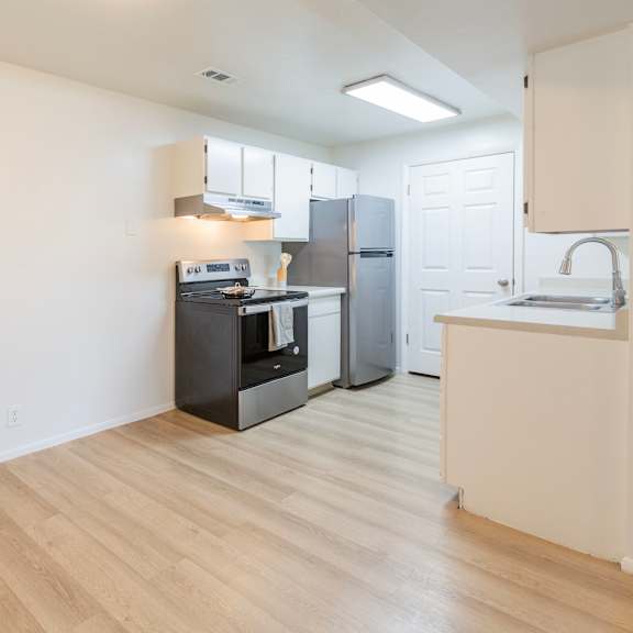 a kitchen with a black stove top oven and white cabinets.