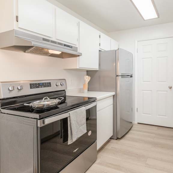 a kitchen with white cabinets and a black stove top oven.