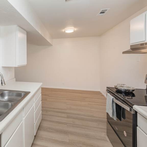 a kitchen with a sink and a stove top oven.