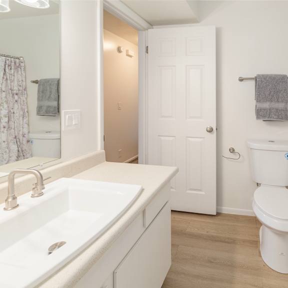 a white bathroom with a toilet, sink, and bathtub.