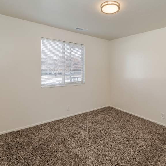 a room with a carpeted floor and a window.
