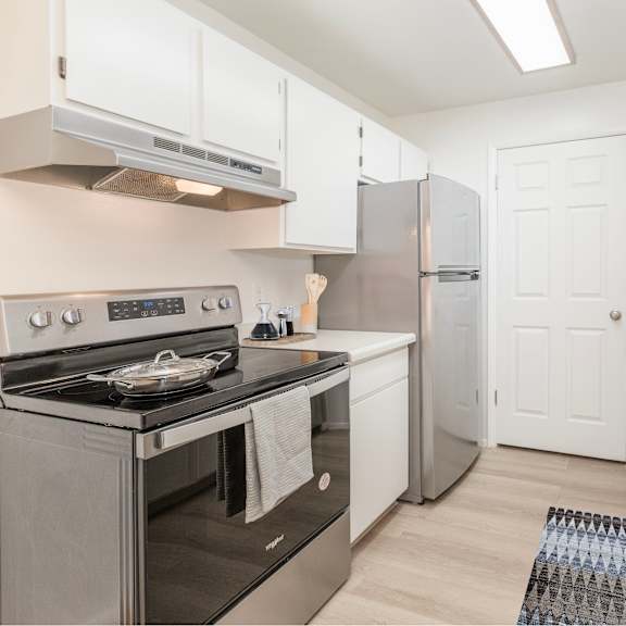 a kitchen with a stove, refrigerator, and sink.
