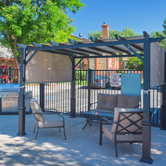 a patio with a table and chairs under a canopy.