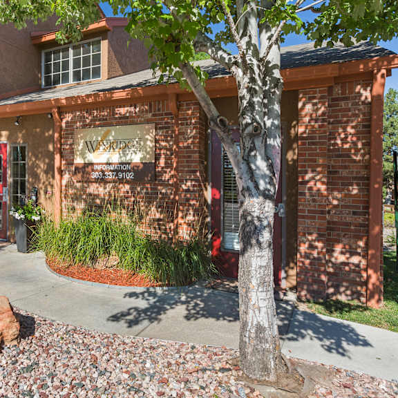 a red door is on the left side of a building.