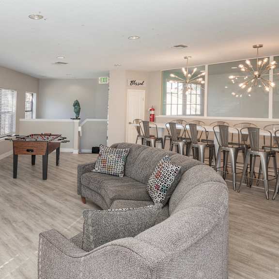 a living room with a grey couch and a fireplace.